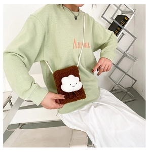Close-up of brown faux shearling crossbody phone bag with cute white cloud emoji charm