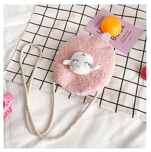 Detail of pink plush crossbody bag featuring a cute lamb cartoon and woven strap