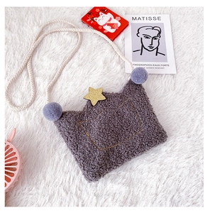 Close-up of gray plush kids crossbody bag with golden star and purple pom-pom detail