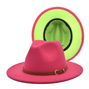 Detail of wool fedora with rose red exterior, neon green brim, and brown leather belt buckle
