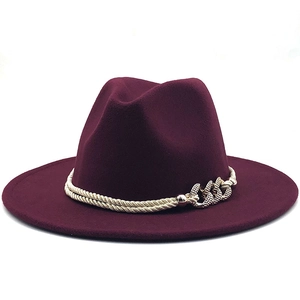 Détail d'un chapeau fedora bordeaux avec doubles cordes tressées beige et boucle chaîne dorée