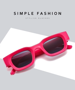 Detailed view of glossy pink rectangular sunglasses with thick frames and dark lenses