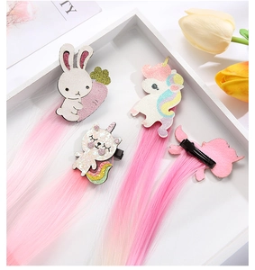 Close-up of colorful sequin unicorn hair clips with long pink gradient hair extensions