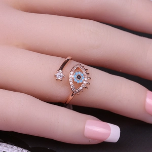Detalle de anillo de ojo turco en oro rosa con piedras azules y circón en la mano