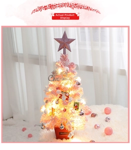 Pink table mini Christmas tree with LED lights and festive ornaments on soft rug