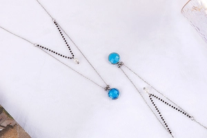 Detailed shot of double-layered silver necklaces with blue crystals and white pearls