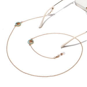 Punk style gold metal glasses chain with turquoise beads and crown pendants on white background
