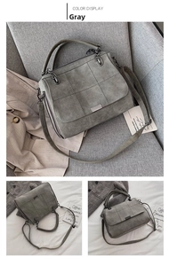Dettaglio della borsa Boston in camoscio grigio con cuciture patchwork e inserti in metallo