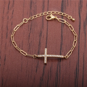 Bracelet croix plaqué or 18 carats avec micro-pavé de zircone sur fond en bois