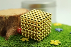 Close-up of 216 pieces 5mm bright gold magnetic balls arranged in a 6x6x6 cube structure