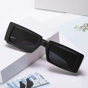 Klassische schwarze rechteckige Sonnenbrille mit glänzendem Rahmen auf weißem Podest