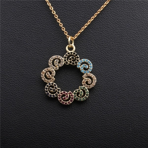 Close-up of golden hollow flower necklace pendant with multicolored micro-set zircons
