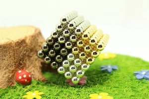 Macro view of 5mm gold and silver magnetic buckyballs in a 6x6x6 cube puzzle set
