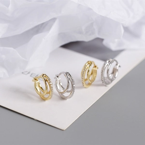 Close-up of double-layer geometric S925 silver hoop earrings with shimmering zircons