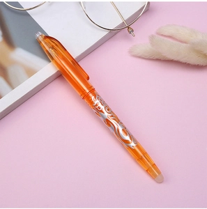 Detail of orange erasable gel pen with dragon design on a soft aesthetic background