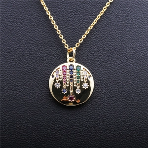 Gold pendant necklace with colorful zircons and fringe stars on dark background