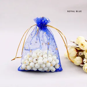 Detail of royal blue organza jewelry bag with gold star patterns and ribbon drawstring