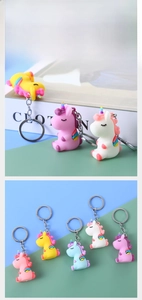 Close-up of cute 3D unicorn keychains in five pastel candy colors with metal rings