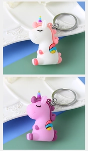 Detail of pink and white unicorn keychains made of soft PVC on a ceramic tray