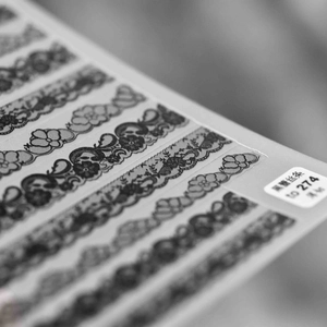 Detailed black lace nail art stickers with intricate floral and wave patterns for manicures