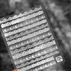 Detail of thin white lace nail art stickers with floral stripes for French manicure