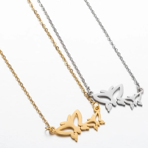 Detailed view of gold and silver butterfly pendant necklaces on white background