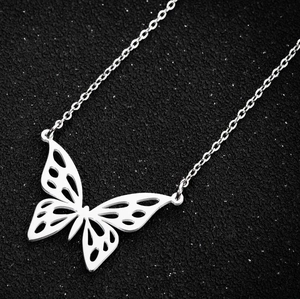 Polished silver stainless steel necklace featuring a hollow butterfly pendant on black background