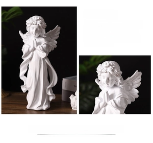 Detailed close-up of a white resin praying angel sculpture with elegant wings and floral crown