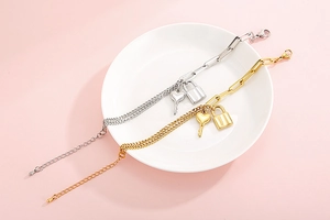 Detail of gold and silver thick chain bracelets with heart key and lock pendants