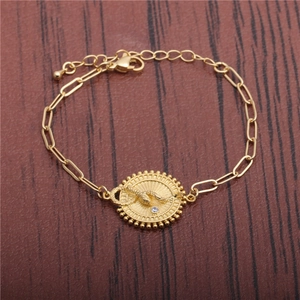 Gold hip hop bracelet with a round snake pendant and sparkling zircon on wood background
