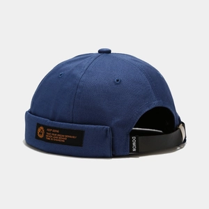 Detail of navy canvas docker hat featuring adjustable leather strap and metal buckle
