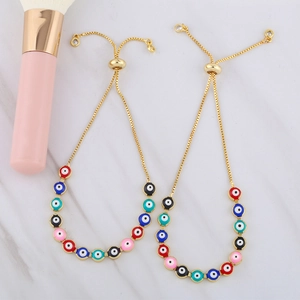 Detail of adjustable evil eye bracelets with colorful enamel eyes and golden bolo chains