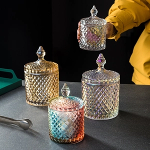 Detailed view of four diamond-patterned glass storage jars in amber and iridescent finishes