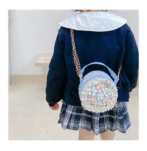 Detail showing the 3D flowers and pearl edge on this blue tweed girls' crossbody bag
