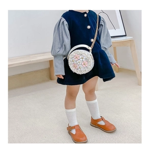 Toddler girl round crossbody bag with 3D floral accents and gold chain strap in use