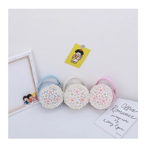Detailed macro view of tweed round mini bags with stereoscopic flowers and pearl beads