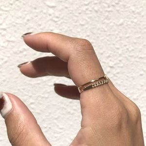 Double-layered gold chain ring worn on the index finger showing minimalist texture
