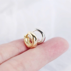 Macro shot of polished S925 sterling silver hoop earrings in gold and silver finishes