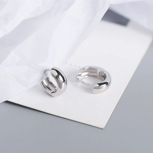 Macro shot of minimalist polished S925 sterling silver geometric wide hoop earrings