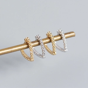 Detailed close-up of S925 sterling silver heart hoop earrings with beaded texture finish