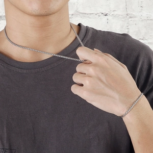 Silver snake bone chain necklace and bracelet set worn by a male model on a white background