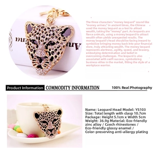 Detailed view of leopard head keychain with purple and white crystals and 10.7cm size scale