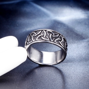 Macro detail of vintage Celtic knot engraving on a wide silver-tone stainless steel ring
