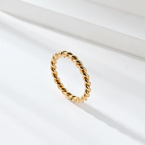 Detail shot of the twisted rope texture on a polished 18K gold Mobius ring with metal shine