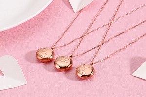 Detail of rose gold zodiac necklaces featuring Cancer, Leo, and Virgo engraved pendants