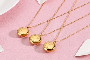 Detail of gold zodiac necklaces showing Cancer, Leo and Virgo engraved round pendants