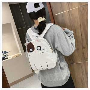 Close-up of white cat-shaped backpack featuring 3D ears and detailed facial embroidery