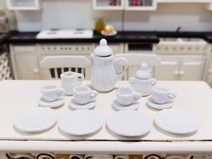Detailed 15-piece set of miniature white ceramic dollhouse tea service on a dining table