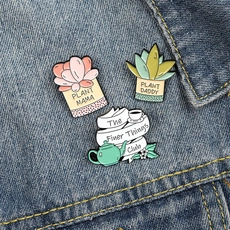Detailed view of Plant Mama and Plant Daddy enamel pins styled on a denim jacket