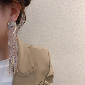 Detail of elegant silver needle drop earrings with sparkling colorful rhinestones and tassels